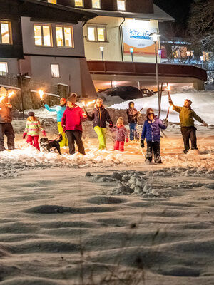 Familienhotel Mein Krug im Fichtelgebirge: Familien im Winter bei Nacht machen eiene Fackelwanderung im Schnee